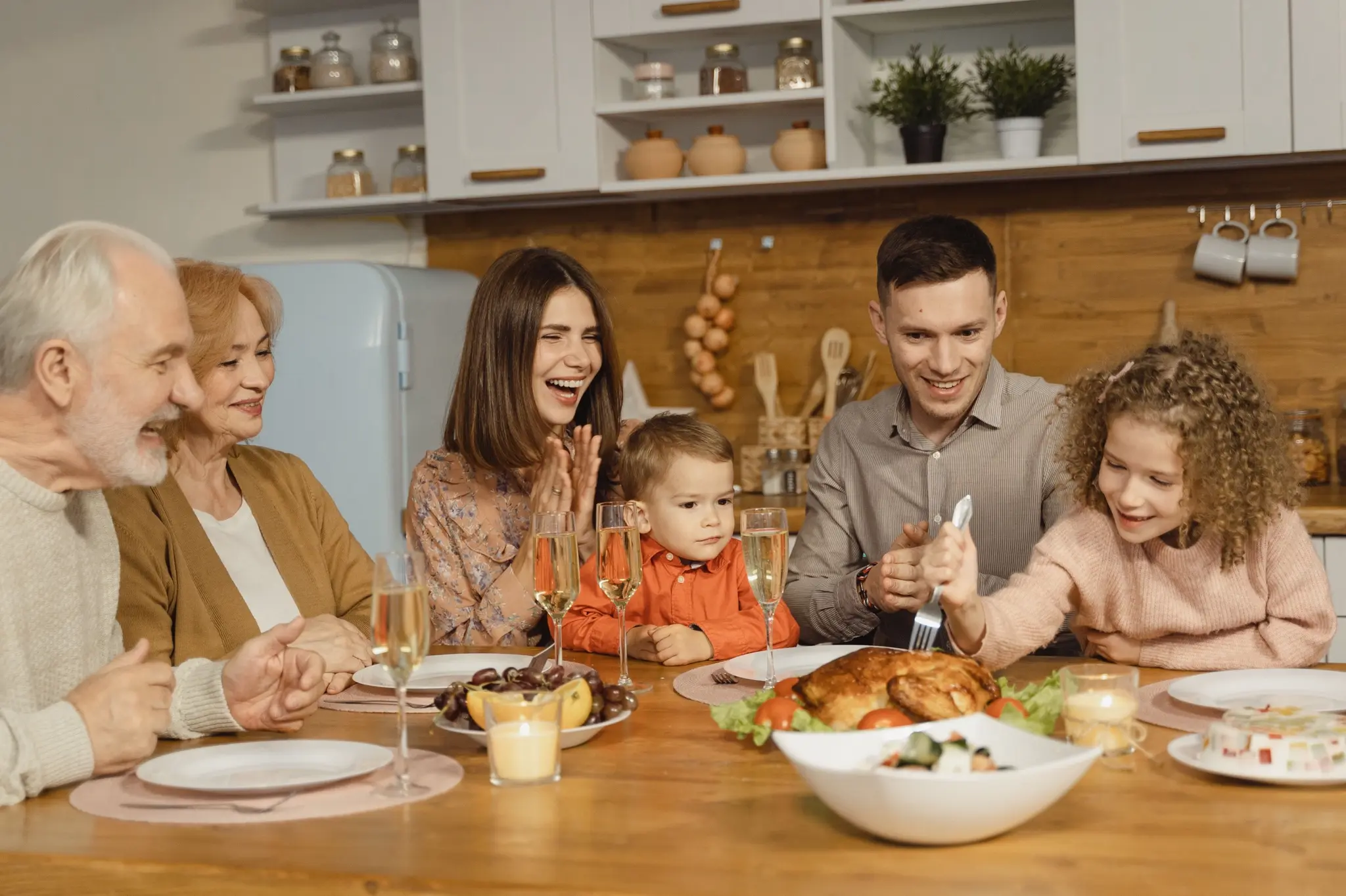 A family laughing together around a holiday dinner table